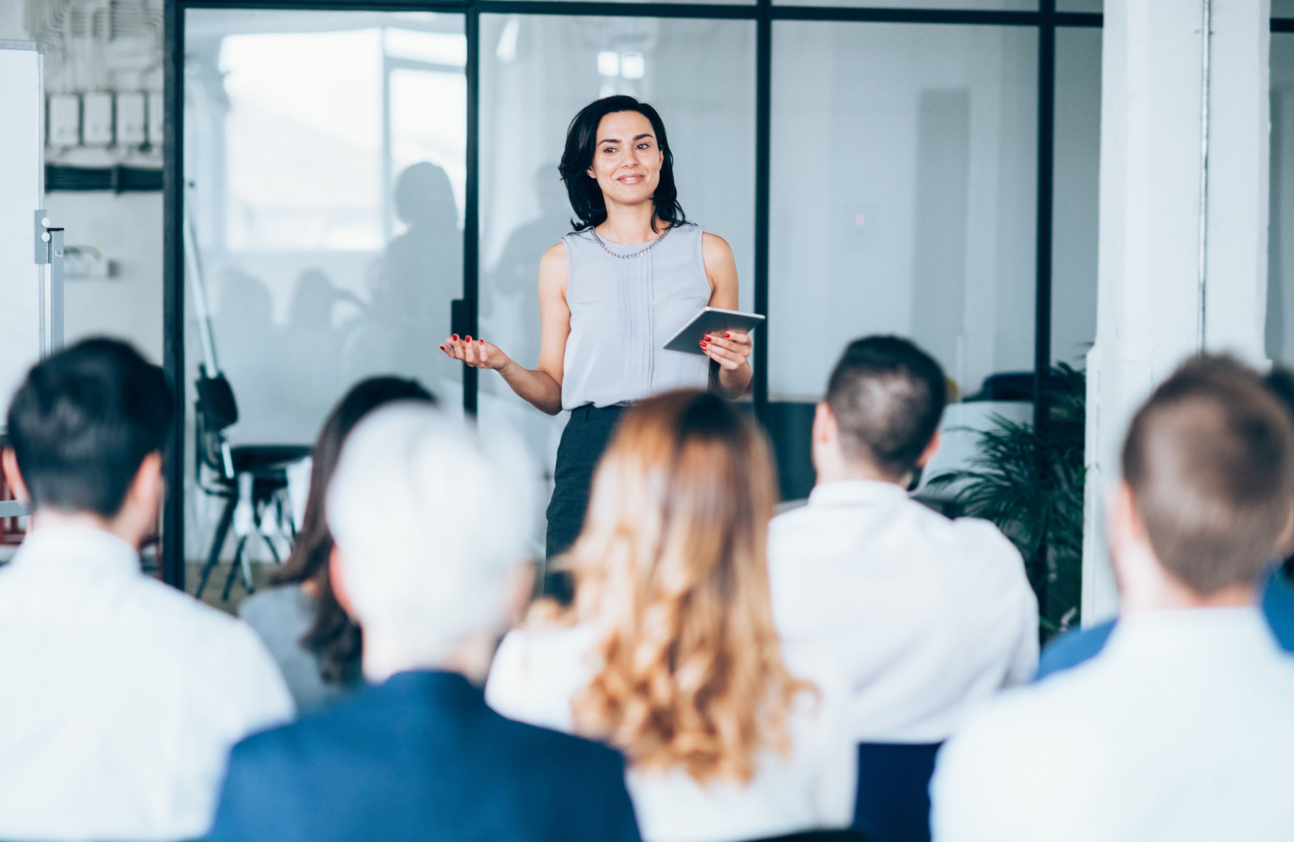 Female professional giving a presentation to a group of colleagues in a conference room